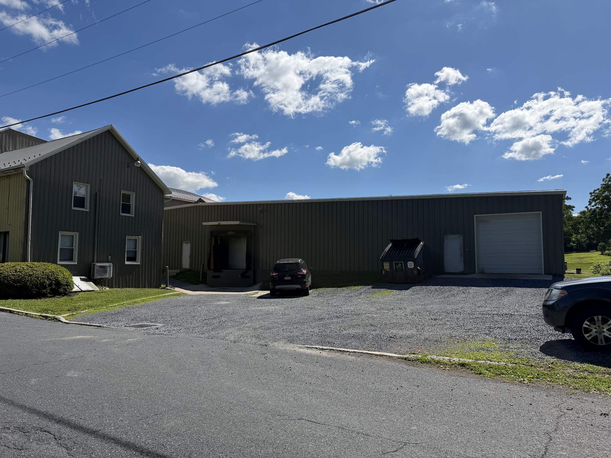 Exterior of the StreetRobin processing facility with loading dock and parking area under a clear sky.