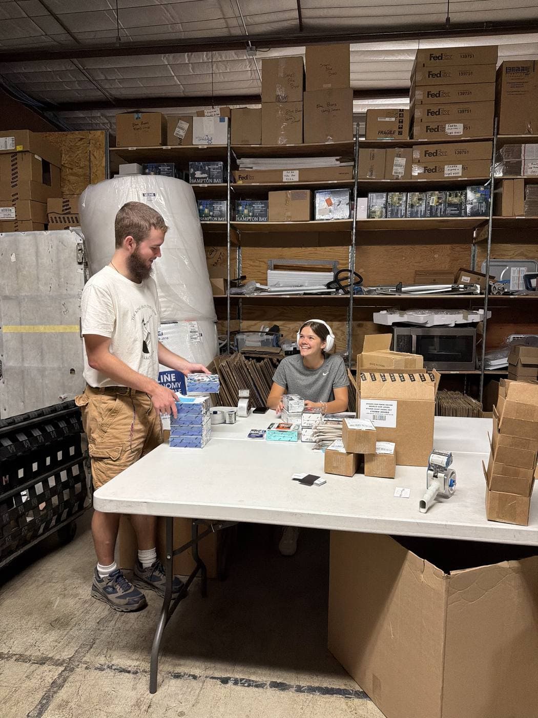 Two StreetRobin team members smiling and working together at a packing station.