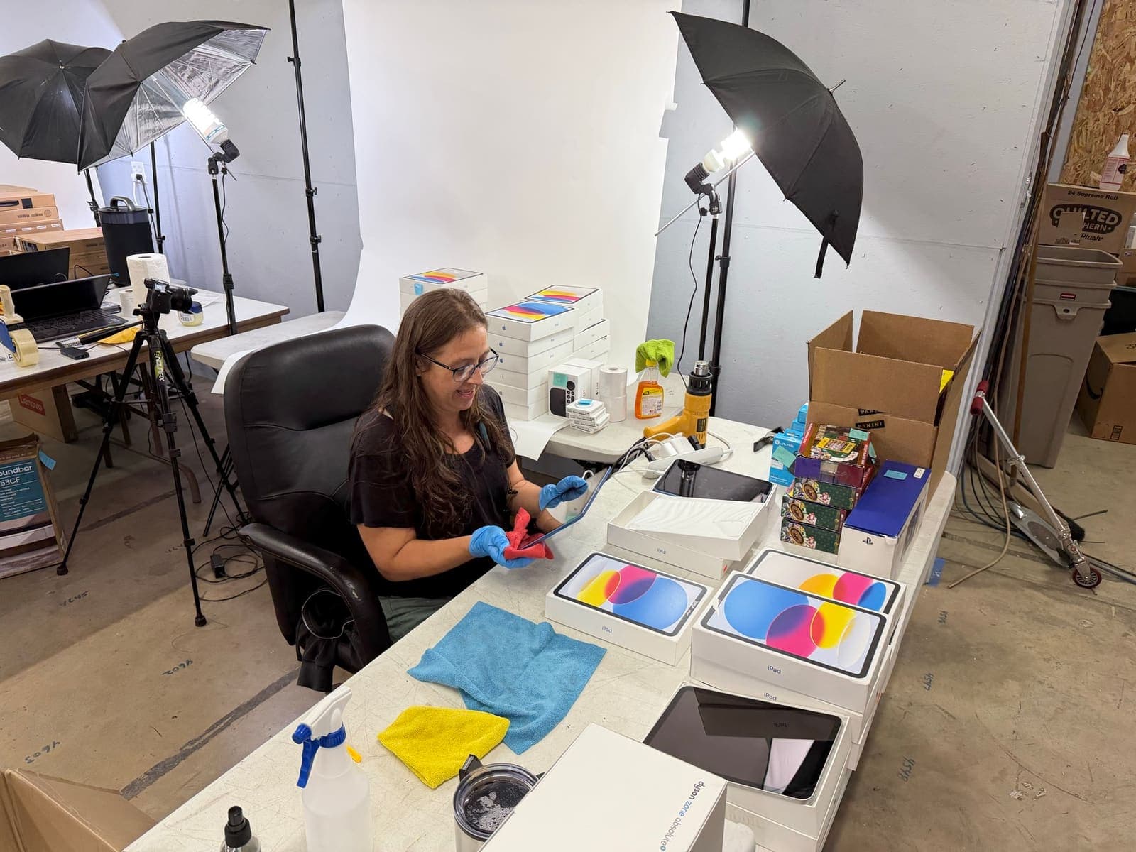 A team member photographing a device at the in-house product-photography station.